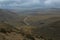 A road leading far away through a dry mountanous landscape in the sierra