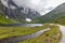 The road leading a mysterious gorge surrounded by clouds of the Norwegian mountains, selective focus