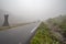 The road leading a mysterious gorge surrounded by clouds of the Norwegian mountains, selective focus