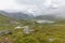 The road leading a mysterious gorge surrounded by clouds of the Norwegian mountains, selective focus