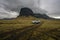 Road leading towards The big and famous moss covered cliff formation Lomagnupur in Iceland with car infront.