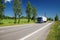 Road lined with poplar alley in the countryside, passing truck