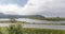 Road and low clouds over green Stor lake, near Bleik , Norway