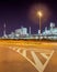 Road markings with illuminated oil refinery on the background