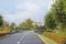 Road with markings to a beautiful old building through the autumn, well-tended park