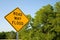 Road May Flood Sign Against A Blue Sky and Green Trees