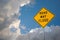 Road May Flood Sign Against A Blue Sky and Storm clouds.