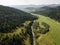 Road through mountains and forest captured from above