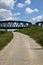 Road that passes under a railway bridge on a clear day in spring in the italian countryside