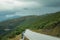 Road passing through hilly landscape with several wind turbines