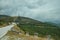 Road passing through hilly landscape with several wind turbines