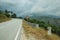 Road passing through hilly landscape and traffic signpost