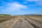 A road piled up on saline alkali land, a salt pond