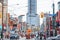 Road repair on a typical American street of downtown Toronto, with Construction barrels, heavy road traffic and detour signs