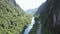 Road and river meander between steep lush forestry banks