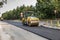 Road roller smoothing the layer of asphalt
