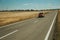 Road through rural landscape and car near the Monfrague National Park