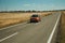 Road through rural landscape and car near the Monfrague National Park