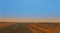 Road through the Sahara with the tombs of old dongola on the horizon