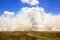 Road in the savannah in the background of the clouds and Smoke