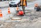 A road service worker repairs a section of the carriageway near a sewer manhole