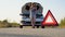 Road side warning triangle, warning oncoming traffic of a broken down car, with a woman using her cell phone to call for