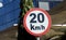 A road sign of 20 KMH twenty Kilometers per hour speed limit in the slow lane near gateway, restaurants and cafes, Prohibitory
