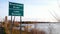 Road Sign at bridge over Mississippi River at Lake Bemidji in early morning Fishing Opener with people trying to catch fish.