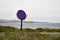 Road sign on the coast of sea, ocean, river, or lake in a cloudy day, morning or evening
