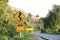 Road sign beside curve mountain road