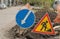 Road sign, detour, road repair on the background of the road and broken asphalt covering