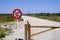 Road sign forbidden with wooden barrier preventing access to cars motorcycles and mopeds vehicles