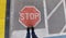 Road sign `Stop` painted on road with two standing feet in front
