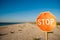 Road sign stop standing on beach sand sea blue sky vacant summer sun