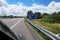 A road sign to the towns of Bar le Duc, Reims and Paris, 272 km away, on an abandoned highway among green trees and grass on the w