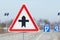 Road sign warning of a crossroads. Regulation of traffic on a highway