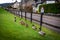 Road sign warning to watch out for ducks and ducklings crossing the road, placed over a fence alongside the road, on a cloudy