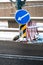 A road sign with a white arrow on a blue background is installed on the roadway. Designation of a dangerous area on the road in