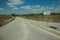 Road with a signpost indicating a nearby village