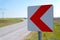 Road signs warning drivers about ahead dangerous curve and blurred car in background