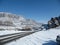 Road slope winter mountain road. rocky mountains in the clouds against a clear blue sky