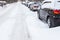 Road in the snow with cars on the roadside