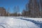 Road in the snow through the forest passage for cars in winter