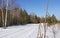 The road in the snow leading to a forest.