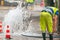 Road spurt water beside traffic cones and repairman