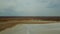 Road in the steppes of Kazakhstan muddy river. View on very long road till horizon.