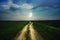 Road stretching into the distance near the green field. Magic blue night sky with moon and stars