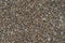 Road surface of small brown and beige pebbles.