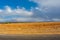 Road to Atlas Mountains in Morocco. yellow and brown grassy fields against blue sky