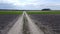 Road to the clouds, passes through a plowed field